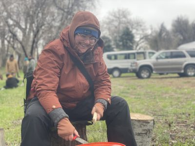 A Changemaker student practices ancestral skills at the ancestral skills gathering at Ollin Farms