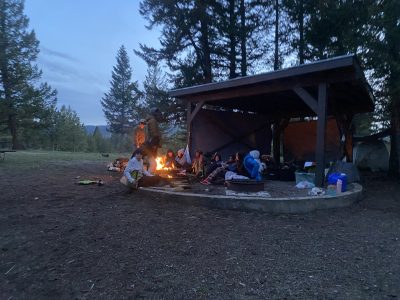 AXL Academy students gather around a campfire on their overnight trip