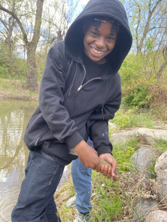 AXL Academy student holding a fish they caught