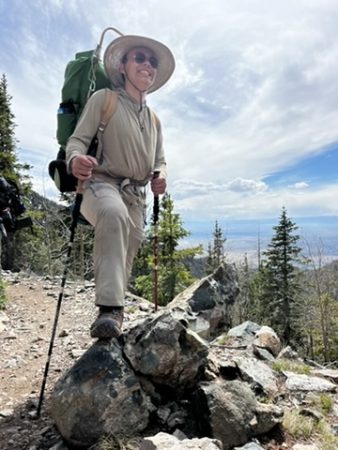 Changemaker student poses in a backpack with hiking poles