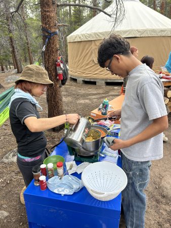 A RiseUp Community High School students cooking dinner during the Watershed Project trip