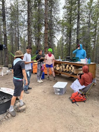 A RiseUp Community High School students cooking dinner during the Watershed Project trip