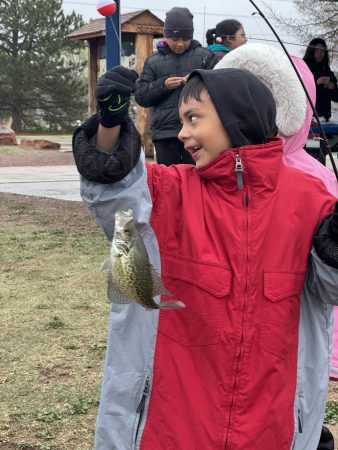 A Casa de la Esperanza youth participants smiles with the fish he caught!