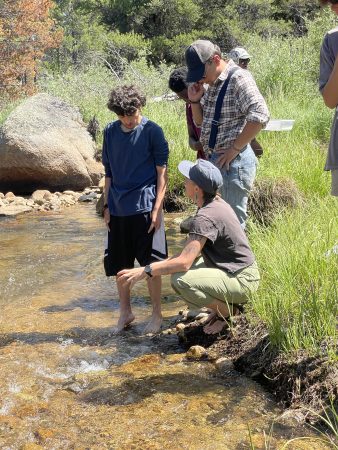 Lincoln Hills Cares Watershed Program participants gather as they wade into the water