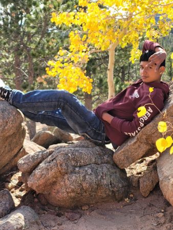 A CHS student relaxes under the yellow leaves of Aspen trees in autumn