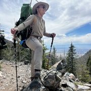 Alum Jesse standing on a trail with his backpack