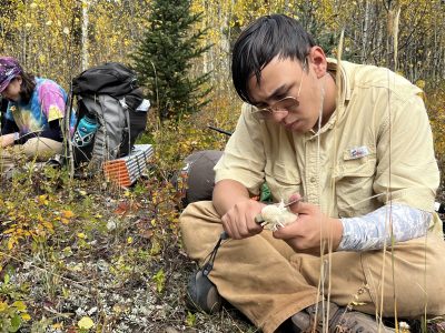 Alum Jesse whittling in the outdoors