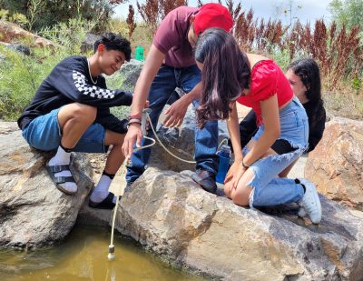 Students share their passion related to the outdoors, and in this photo they collaborate to filter water from a creek.