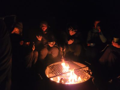 Students gather around a campfire on the alumni solstice hike.