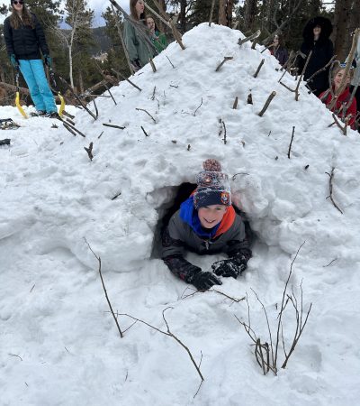 One student exits the quinzhee after a day of challenge and adventure.